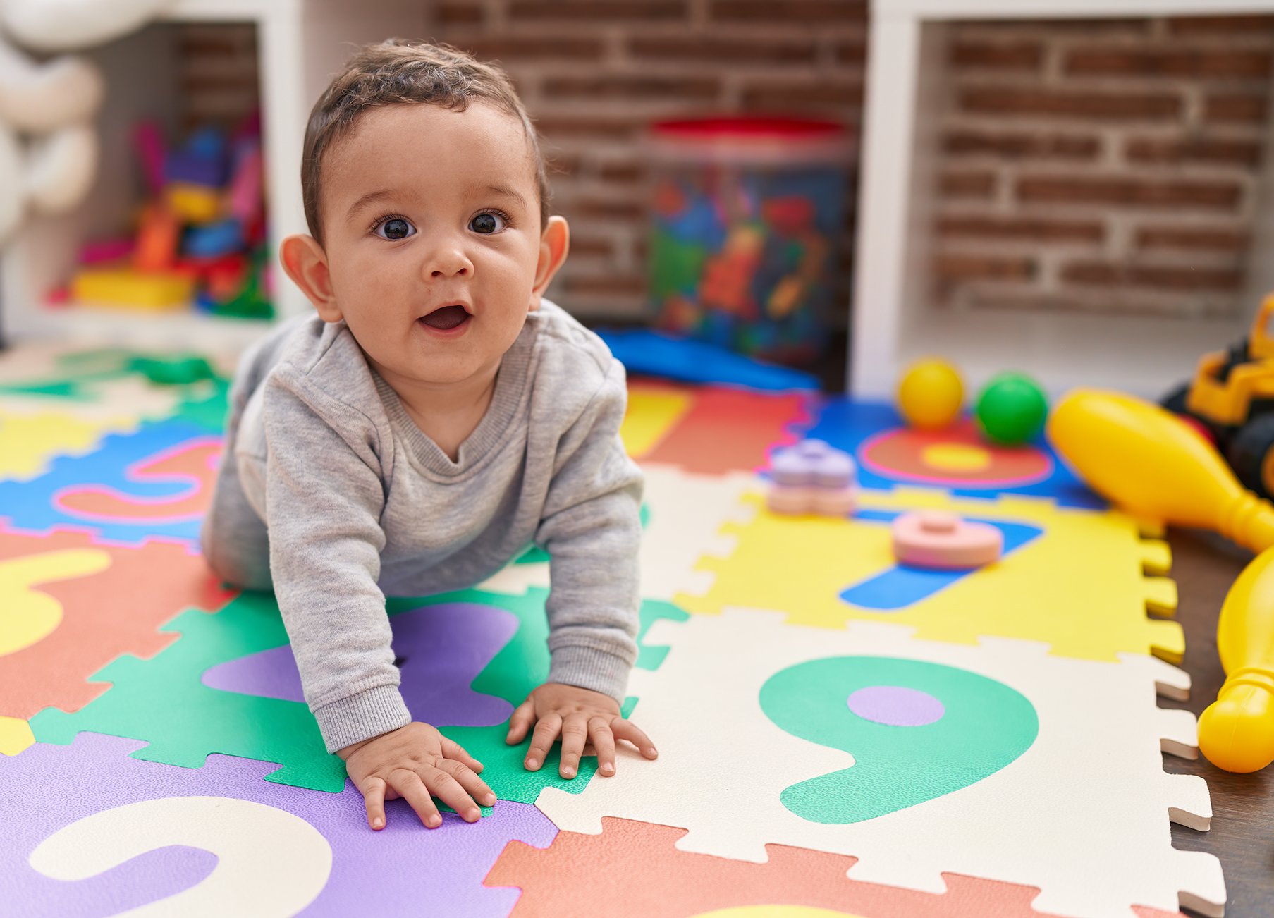 Infant crawling on a mat