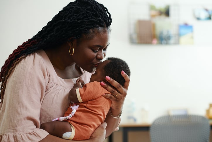 mother kissing babies forhead